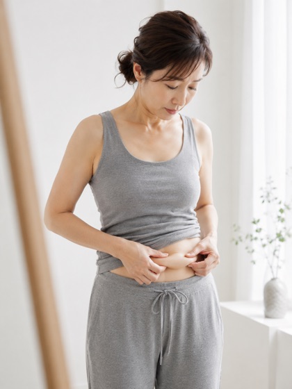 お腹まわりを気にする女性